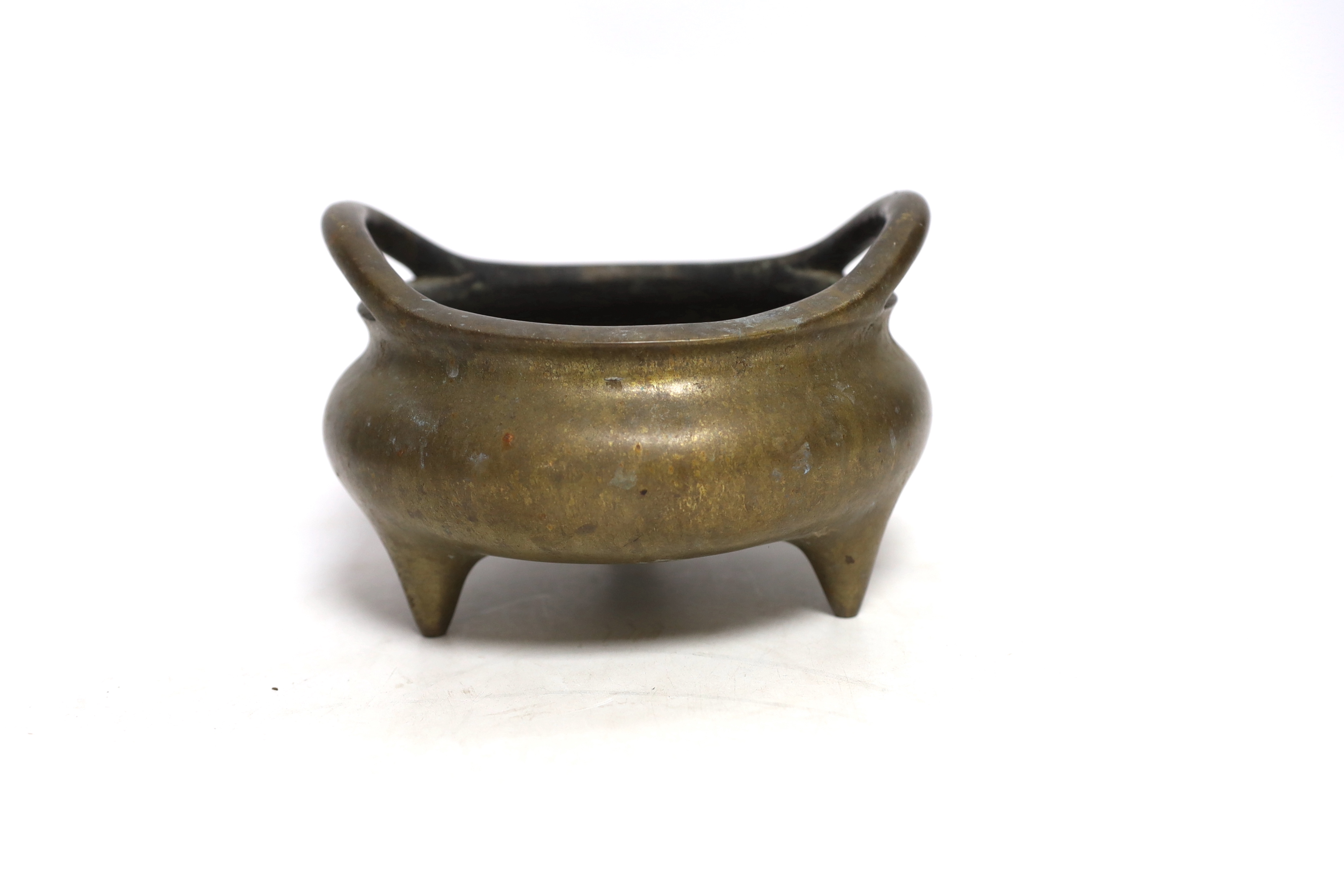 A Chinese bronze censer with twin handles and tripod feet, 18cm wide